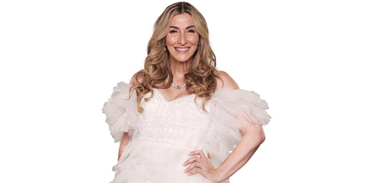 Morena Farina from MAFS 2025, a woman with long wavy blonde hair, smiles while wearing a white wedding dress with voluminous tulle sleeves and a pearl necklace