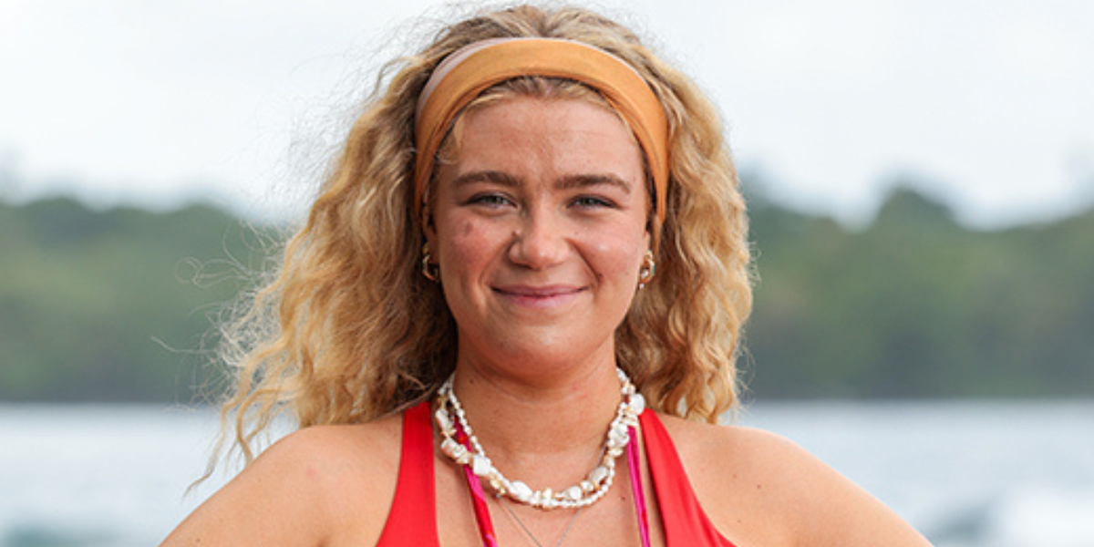 Laura from Australian Survivor 2025 Brains v Brawn II with an orange headband, shell necklace and red tank top smiling against a coastal backdrop