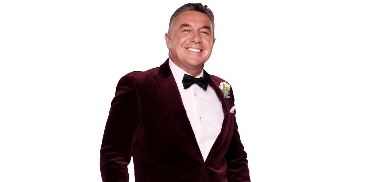 Tony Mojanovski from MAFS 2025, a man with short dark hair, smiles while wearing a burgundy velvet suit with a black bow tie and a white boutonniere