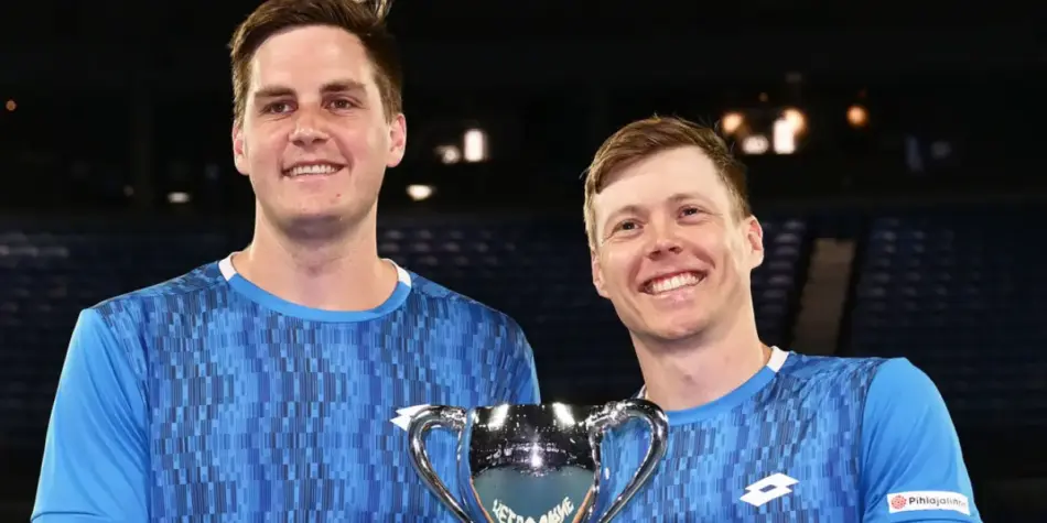 Harri Heliovaara and Henry Patten smiling and holding their trophy after their victory at the Australian Open 2025