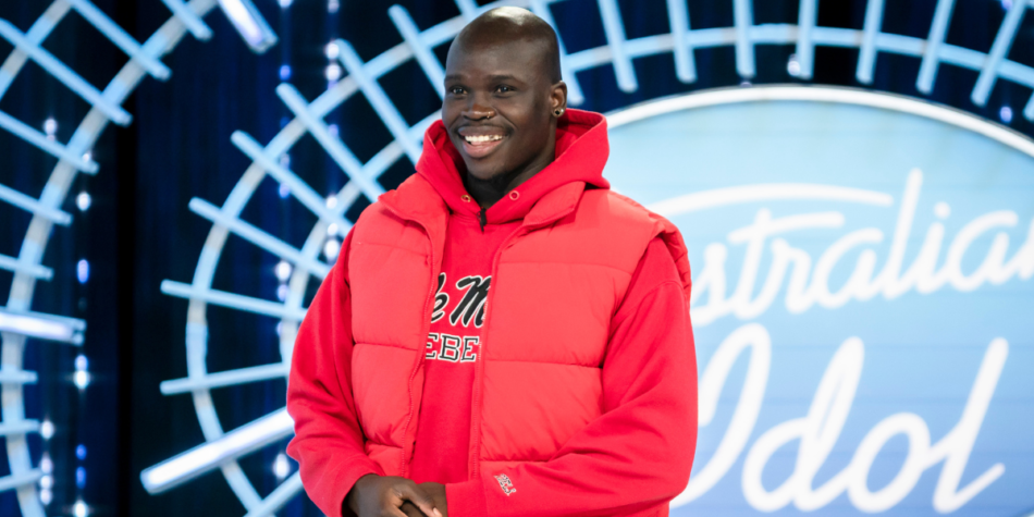 Bony Onyango smiles during his Australian Idol 2025 audition, wearing a red hoodie and vest