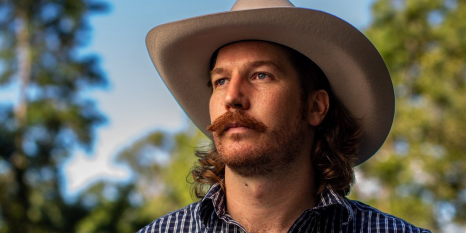 Jake Whittaker from Australian Idol 2025 in a cowboy hat, gazing into the distance outdoors