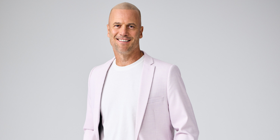 Promotional image of Mike from Love Triangle Season 3 (2025), wearing a sleek pastel pink blazer over a white t-shirt, smiling confidently against a neutral backdrop